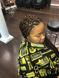 a woman with braids sitting in a salon chair