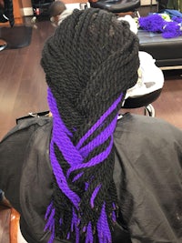 a woman with black and purple braids in a salon