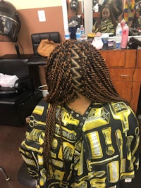 the back of a woman with braids in a salon