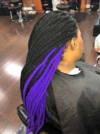 a woman with purple and black braids in a salon