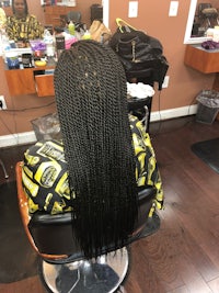 a woman with long braids sitting in a chair at a salon